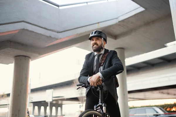 Hipster viajero de negocios con bicicleta eléctrica viajando a casa desde el trabajo en la ciudad . — Foto de Stock