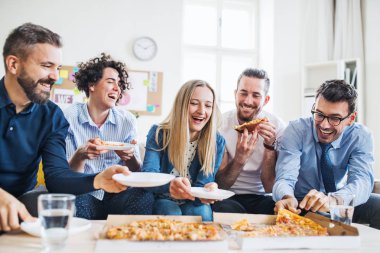 Modern bir ofiste yemek pizza ile Genç İşadamları grubu.