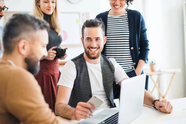 Groep van jonge ondernemers met laptop samen te werken in een modern kantoor. — Stockfoto
