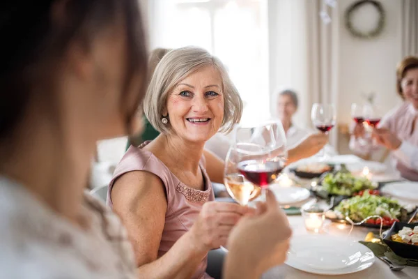 Eine große Familie sitzt an einem Tisch auf einer Geburtstagsparty im Haus und klimpert mit Gläsern. — Stockfoto