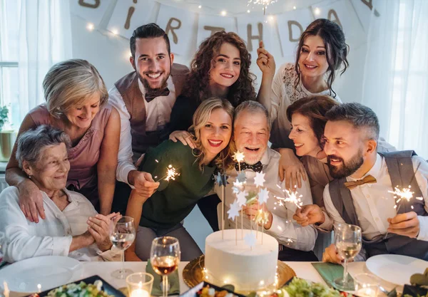 Старший чоловік з сім'єю багато поколінь, що святкує день народження на критій вечірці . — стокове фото