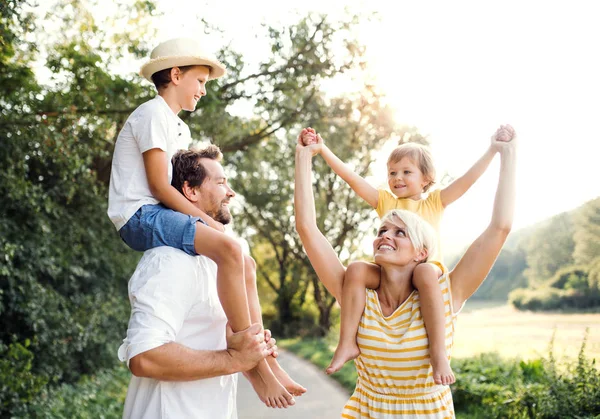 Família jovem com crianças pequenas na natureza ensolarada do verão . — Fotografia de Stock