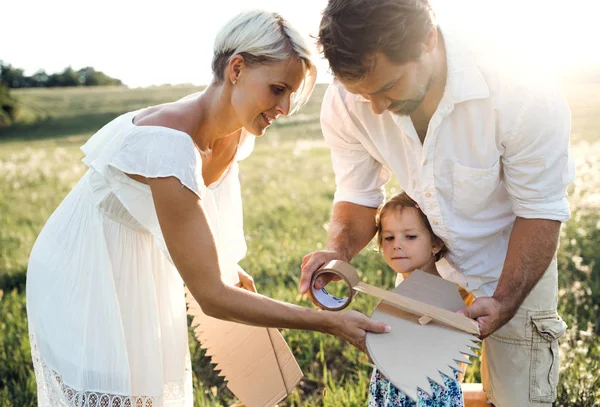 Junge Familie mit kleiner Tochter spielt auf einer Wiese in der Natur. — Stockfoto