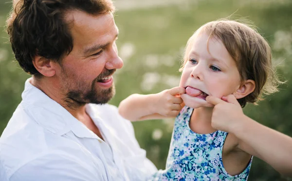 Unga far i naturen innehav liten dotter i armarna, ha roligt. — Stockfoto