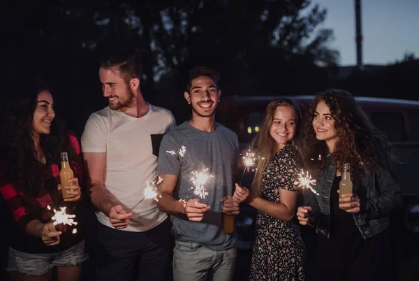 Arkadaşlar ayakta açık havada akşam parıldıyor ile bir grup. — Stok fotoğraf