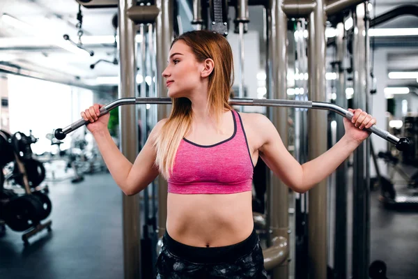 Uma visão frontal de menina ou mulher fazendo exercícios de força em um ginásio . — Fotografia de Stock