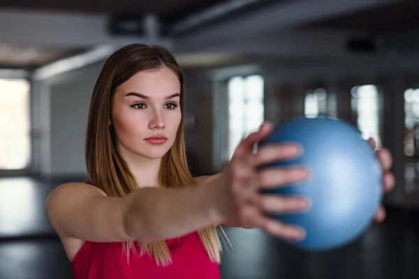 Портрет молодої дівчини або жінки, що займається фізичними вправами з м'ячем у спортзалі . — стокове фото