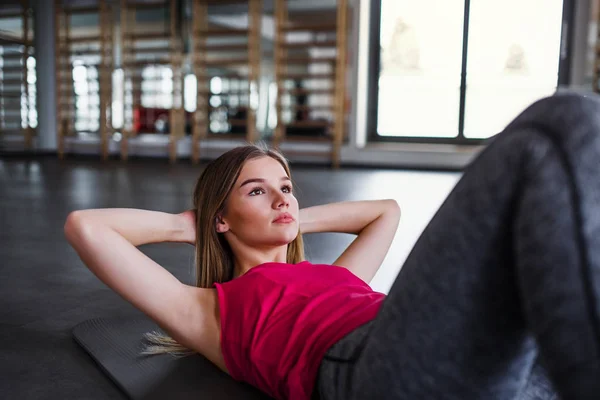 Um retrato de menina ou mulher fazendo exercício em um ginásio . — Fotografia de Stock