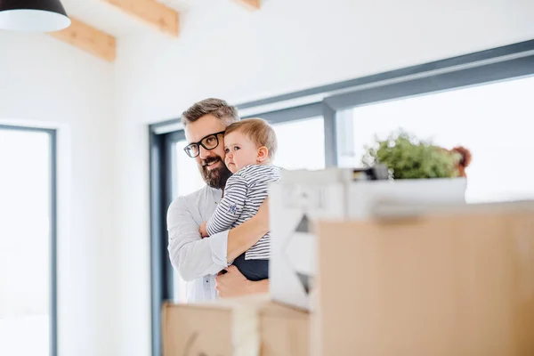 A portrait of young father with a toddler girl moving in new home. — Stock Photo, Image