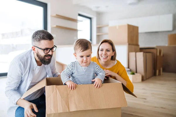 Portrait d'une jeune famille avec une fillette déménageant dans une nouvelle maison . — Photo