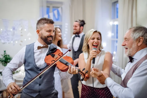 Une jeune mariée, marié et autres invités dansant et chantant lors d'une réception de mariage . — Photo
