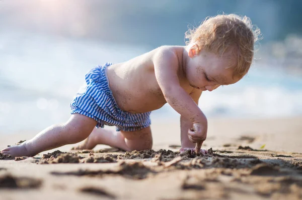 Een kleine peuter meisje op strand op zomervakantie, spelen. — Stockfoto