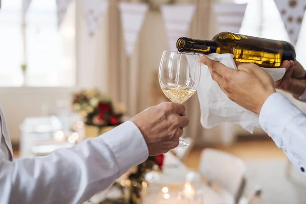 Una sección media del hombre que vierte el vino de los huéspedes en una fiesta de cumpleaños de la familia cubierta . —  Fotos de Stock