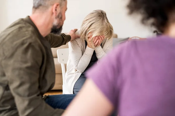 Een senior depressief vrouw huilen tijdens groepstherapie. — Stockfoto