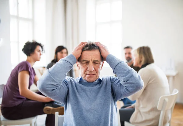A portrait of senior depressed man during group therapy. — Stock Photo, Image