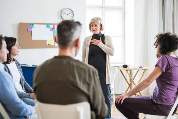 A woman talking to other people during group therapy. — Stock Photo, Image