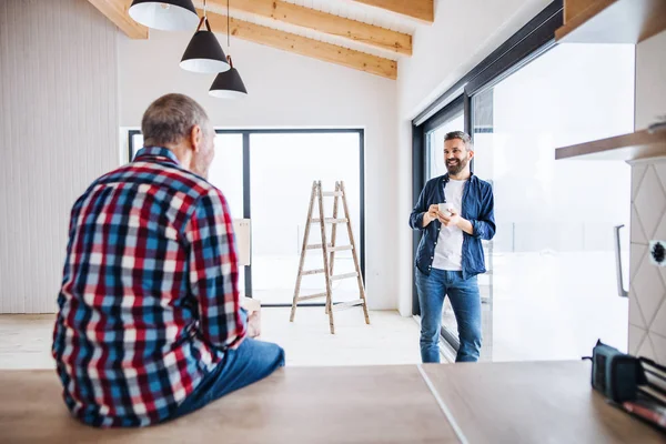 Un homme mûr avec son père aîné ameublement nouvelle maison, un nouveau concept de maison . — Photo