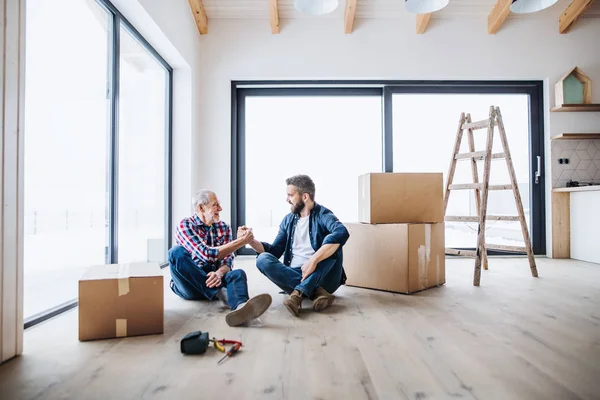 En mogen man med sitt ledande far inredning nya hus, ett nytt hem koncept. — Stockfoto