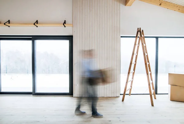 Ein Mann, der mit Kartons unterwegs ist, wenn er sein neues Haus einrichtet. Bewegungsunschärfe. — Stockfoto