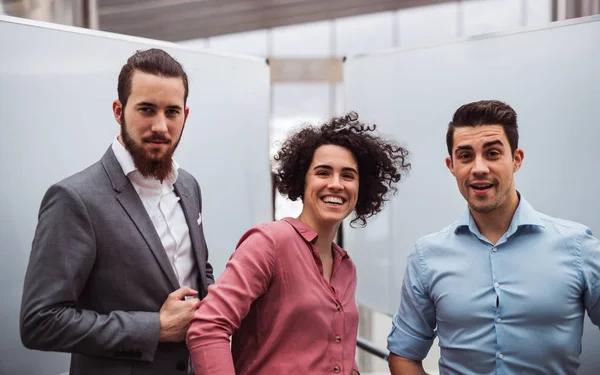 Jonge ondernemers staan in office, camera kijken. — Stockfoto