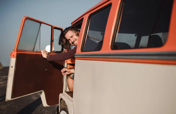 Ein junger Mann beim Aussteigen aus einem Auto auf einem Roadtrip durch die Landschaft. Kopierraum. — Stockfoto