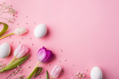 Paskalya ve bahar düz pembe bir arka plan üzerinde yatıyordu. Kopya alanı.