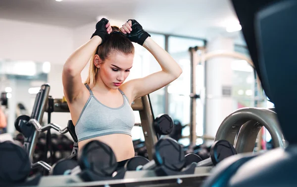A portrait of young girl or woman doing exercise in a gym. — Stock Photo, Image