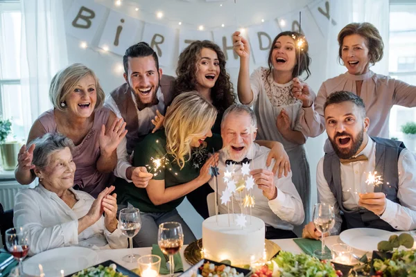 Um homem sênior com família multigeracional comemorando aniversário em festa indoor . — Fotografia de Stock