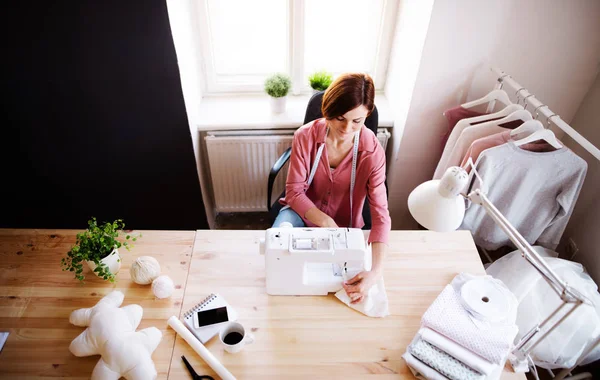 Joven mujer creativa en un estudio, trabajando. Una puesta en marcha de negocio de sastrería . —  Fotos de Stock