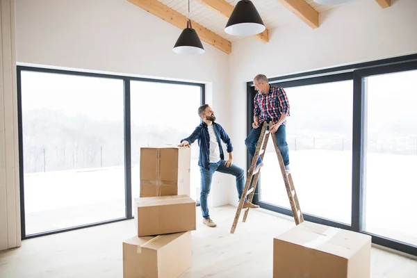 Un homme mûr avec son père aîné ameublement nouvelle maison, un nouveau concept de maison . — Photo