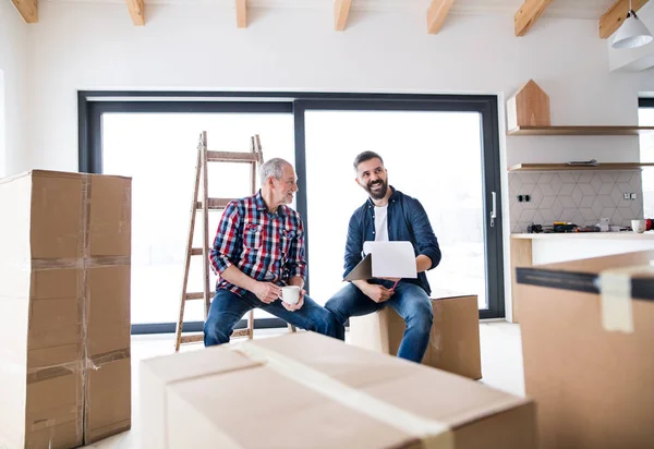 Un homme âgé aidant son fils à meubler une nouvelle maison, un nouveau concept de maison . — Photo