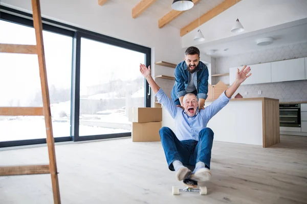 Deux hommes s'amusent lors de l'ameublement d'une nouvelle maison, un nouveau concept de maison . — Photo