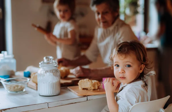 Ανώτερος γιαγιά με μικρά νήπια παιδιά καθιστώντας τα κέικ στο σπίτι. — Φωτογραφία Αρχείου