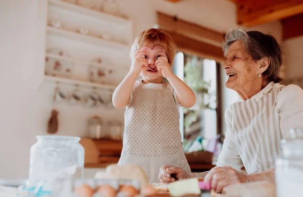 Senior nonna con piccolo bambino ragazzo fare torte a casa . — Foto Stock