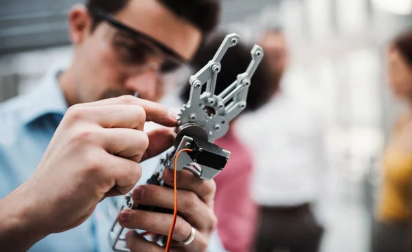 Egy fiatal üzletember vagy tudós robotikus kezét állt az irodában, munka. — Stock Fotó