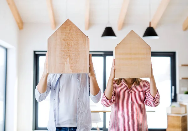 Um jovem casal com casas de madeira, um movimento no novo conceito de casa . — Fotografia de Stock