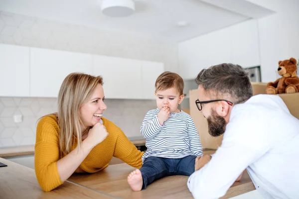 A portrait of young family with a toddler girl moving in new home. — Stock Photo, Image