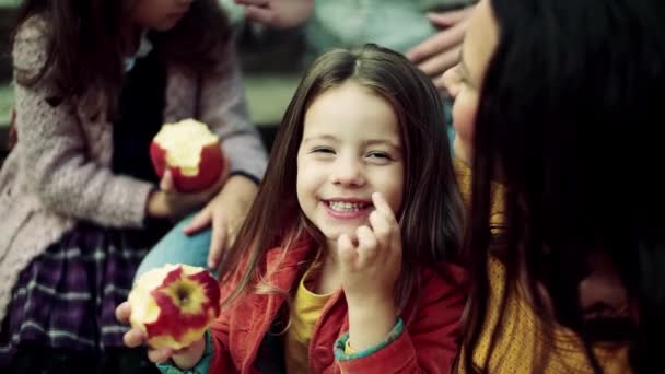 Malá dívka s rodinou piknik v podzimní přírodě, jablko. — Stock video