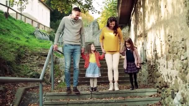 Молодая семья с детьми на лестнице на открытом воздухе в городе осенью . — стоковое видео