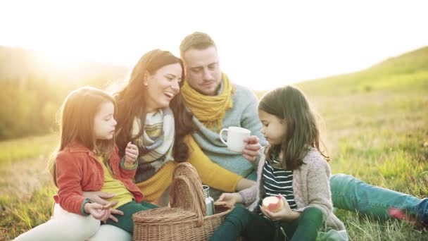 İki küçük çocuklu autumn doğada piknik genç bir aile. — Stok video