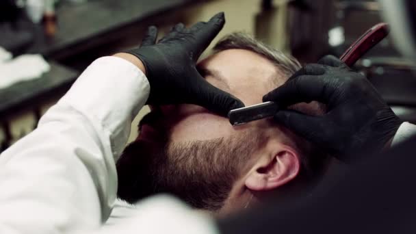 Un primer plano del cliente hombre visitando haidresser en la peluquería, recorte de barba . — Vídeo de stock