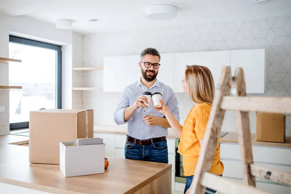 A young couple drinking coffee when moving in new home. — Stock Photo, Image