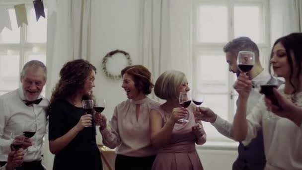 Une famille multigénération cliquetis lunettes sur une fête d'anniversaire de famille intérieure .