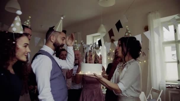 Портрет родини мульти-покоління з тортом на день народження в приміщенні, конфетті падає . — стокове відео