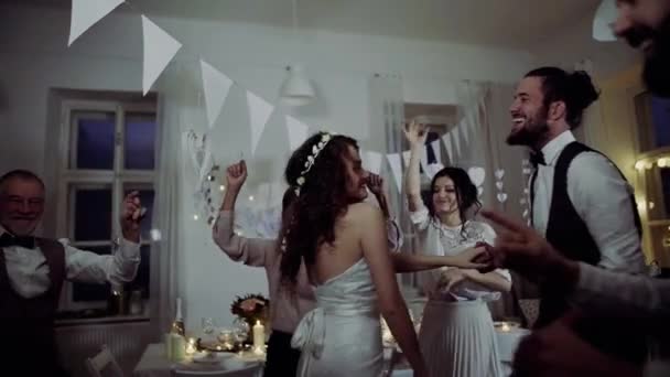En unga bruden, brudgummen och gäster som dansar på en bröllopsfest. — Stockvideo