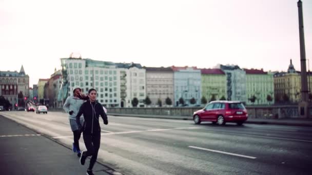 Una pareja en forma corriendo al aire libre en las calles de la ciudad de Praga. Movimiento lento . — Vídeos de Stock