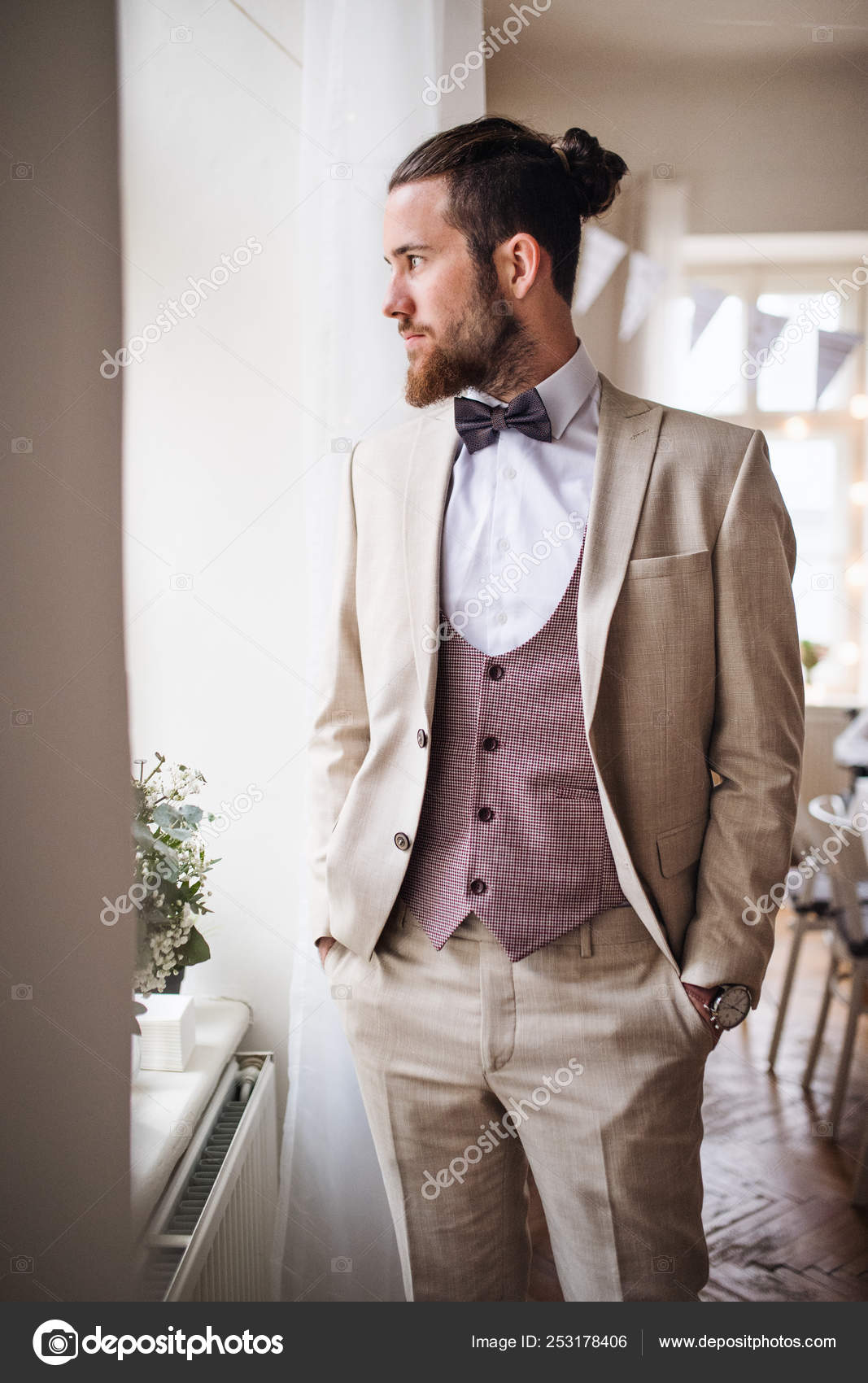 A handsome hipster young man with formal suit standing on an indoor party.  Stock Photo by ©halfpoint 253178406