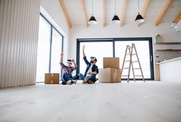 Un homme et son père aîné avec lunettes VR ameublement nouvelle maison, un nouveau concept de maison . — Photo