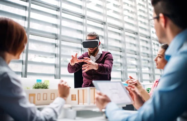 Grupo de jovens arquitetos com modelo de uma casa e óculos VR trabalhando no escritório . — Fotografia de Stock