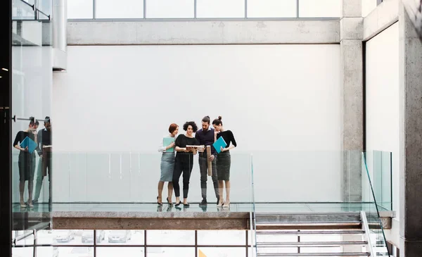 Grupo de jovens empresários perto de uma escadaria, conversando . — Fotografia de Stock